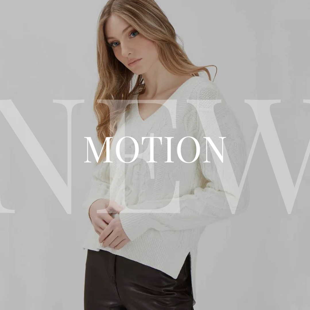 A woman wearing a white sweater and leather pants with the words motion.