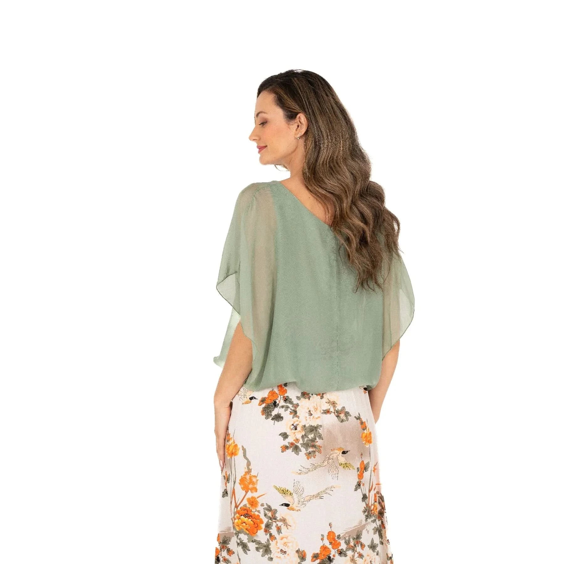 A woman with long hair is wearing a comfortable and stylish Ladies Woven Top by M Made In Italy in light green and a floral skirt, standing sideways against a plain white background.