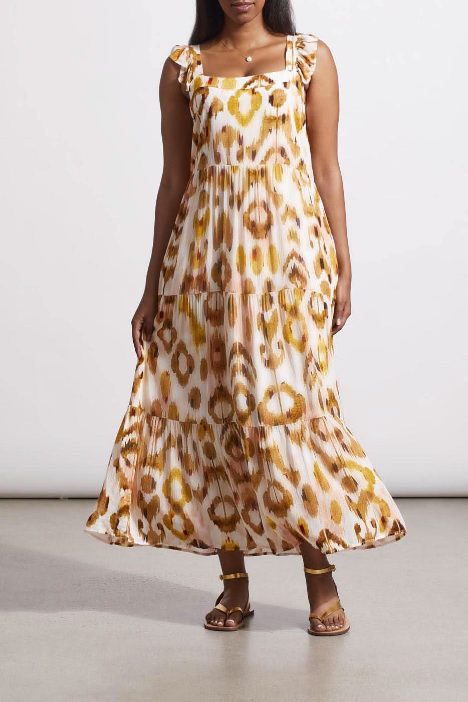 Woman in a versatile tie-dye patterned Tribal Flutter Strap Maxi Dress and brown sandals standing against a neutral background.