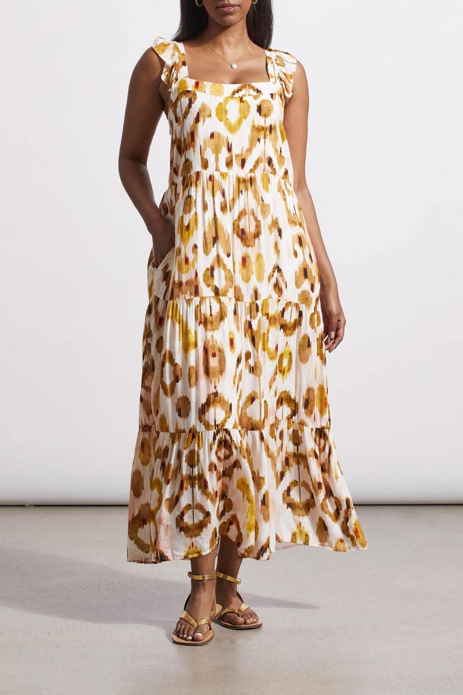 Woman in a versatile tie-dye patterned Tribal Flutter Strap Maxi Dress and brown sandals standing against a neutral background.