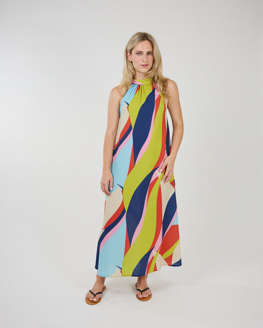 Woman in a colorful, eye-catching print Shannon Passero Long Waveprint Latanya Dress standing against a white backdrop.