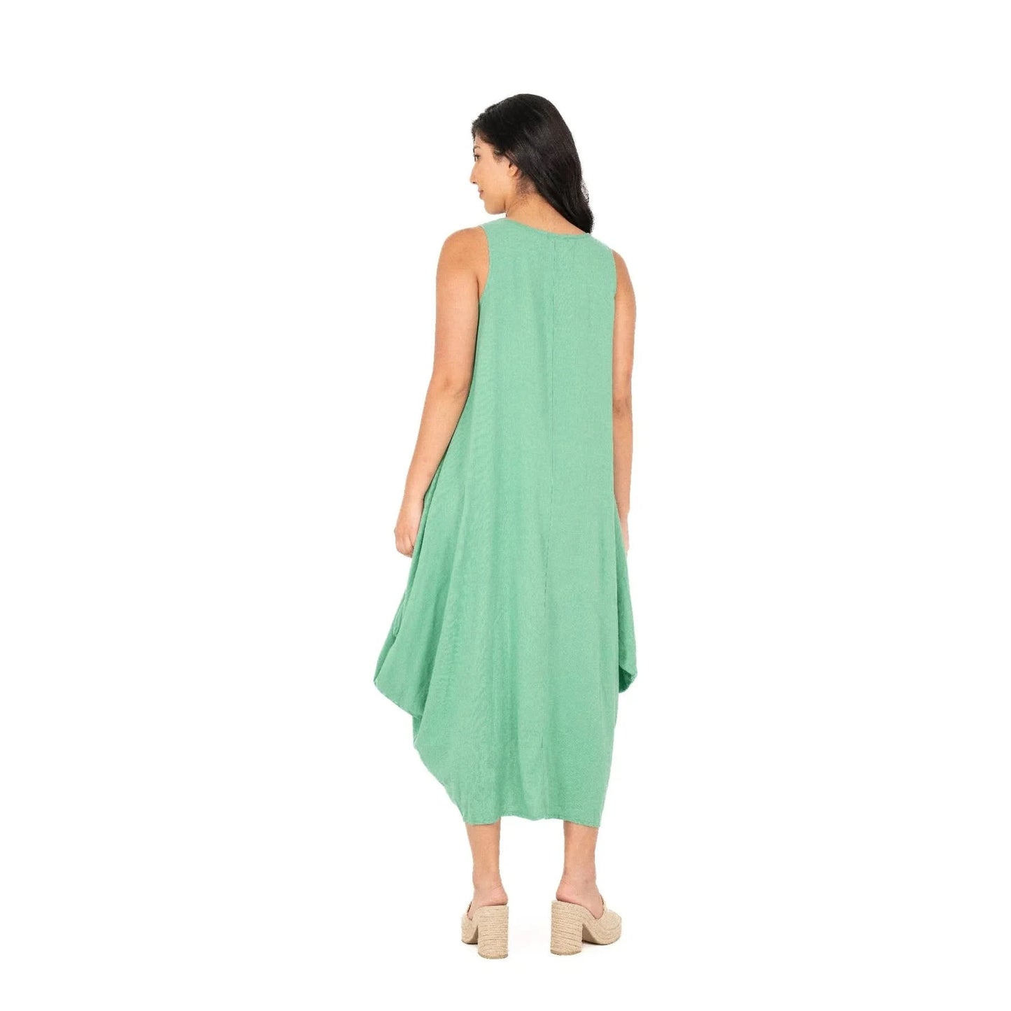 A person exudes effortless chic wearing the M Made In Italy Sleeveless Jade Dress with pockets, set against a plain white backdrop.