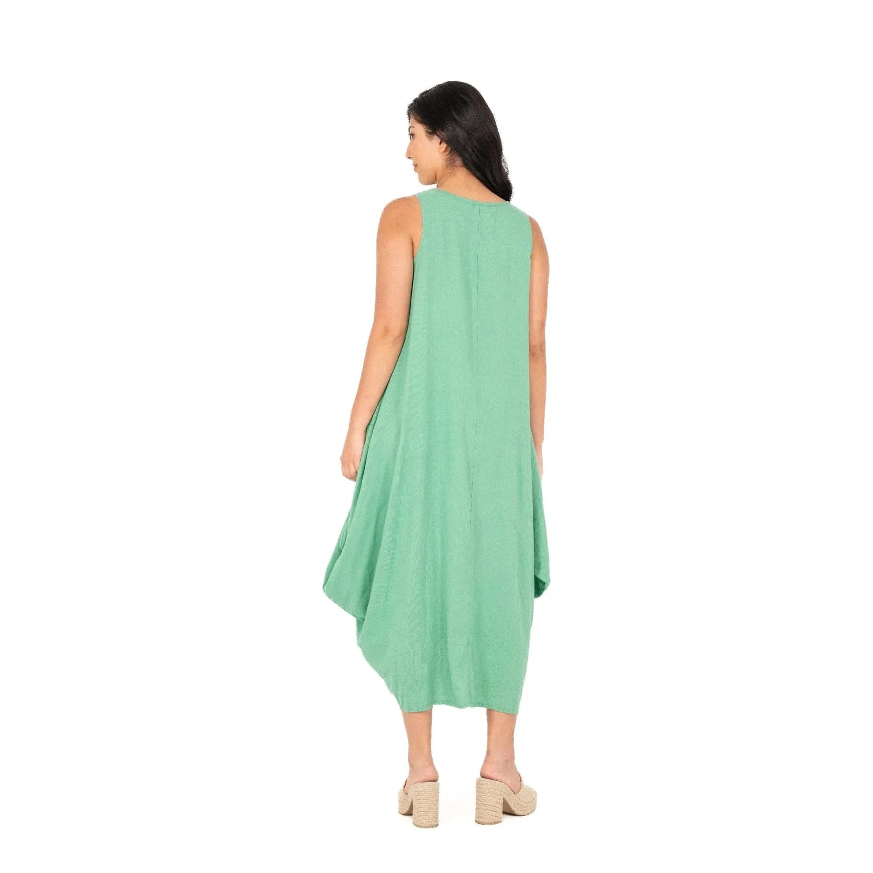A person exudes effortless chic wearing the M Made In Italy Sleeveless Jade Dress with pockets, set against a plain white backdrop.