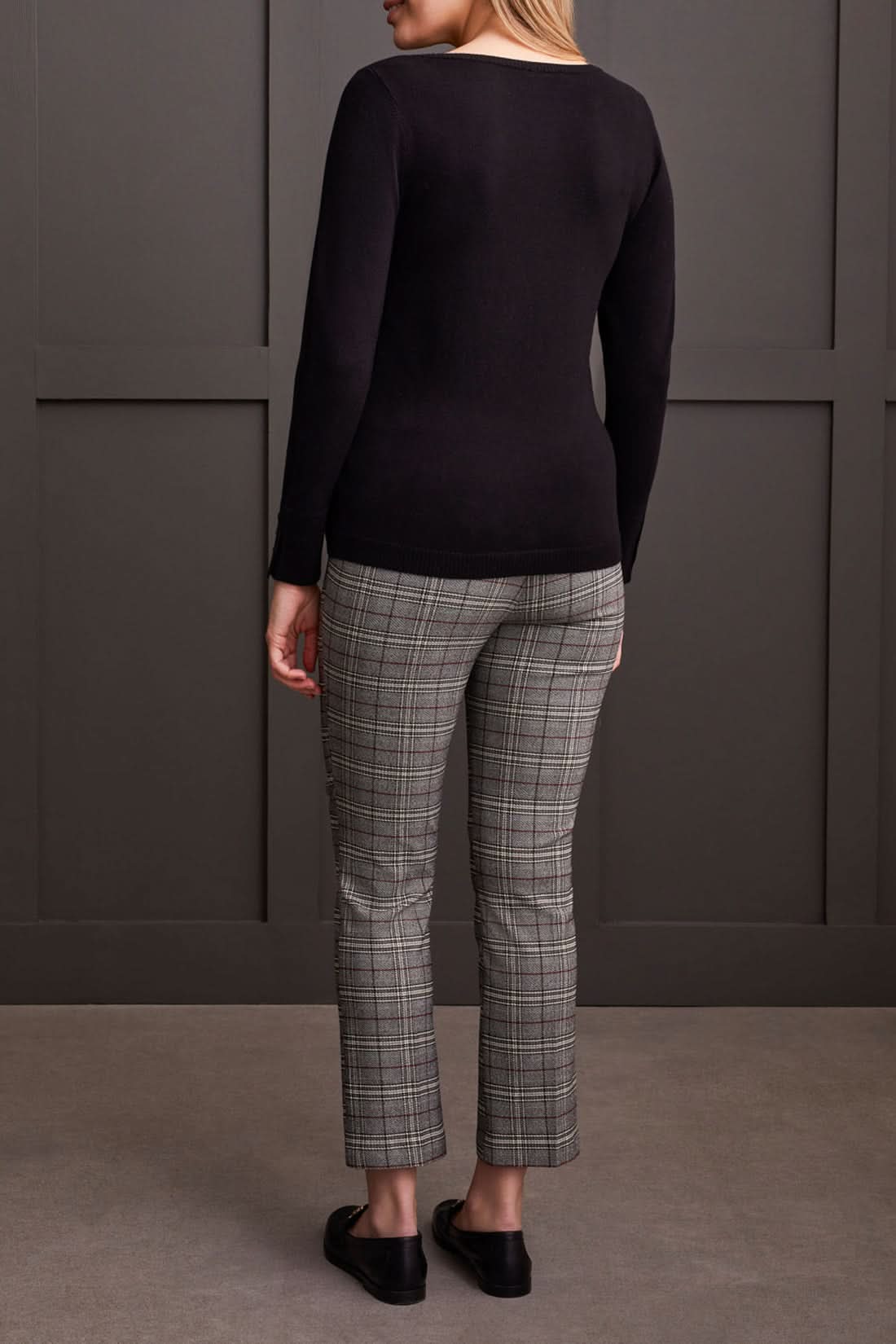 A person wearing a Tribal Boat Neck Sweater with long sleeves and button sleeve details, standing in front of a dark background.