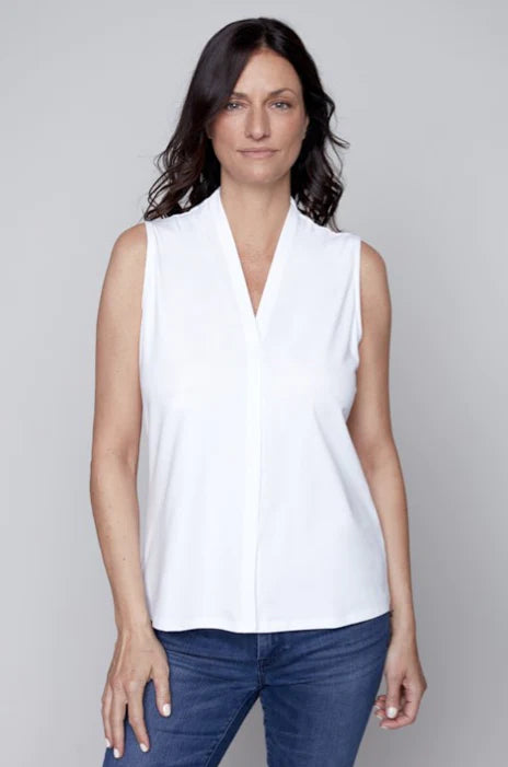 A versatile woman wearing a Claire Desjardins sleeveless knit top and jeans, adding versatility to her wardrobe.