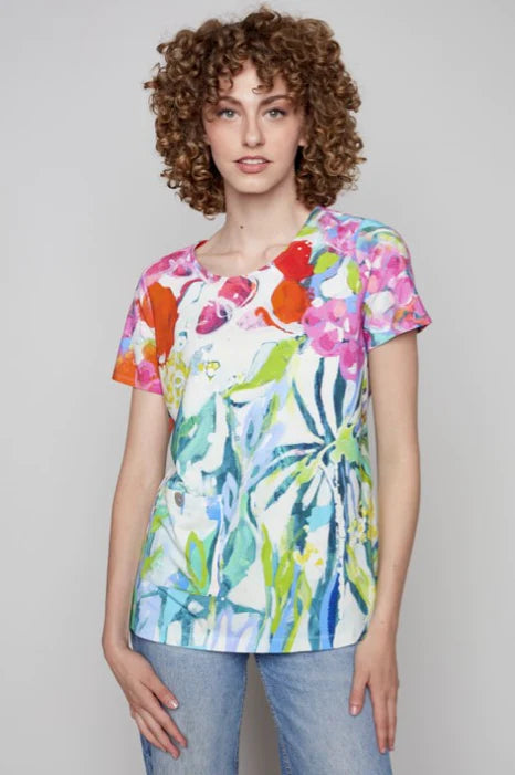 A woman wearing a high-quality and comfortable Claire Desjardins Liberty Garden Knit Top featuring a colorful printed t-shirt.
