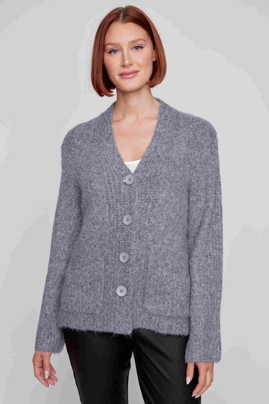 A person is wearing a Fuzzy Button Up Cardigan from CoCo Y Club in blue, paired with a white top and dark pants, posing against a plain background.