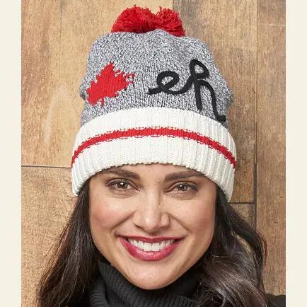 A woman sporting a Canada Eh Pom Touque made of recycled cotton yarn with a Canadian flag, from Cotton Country.