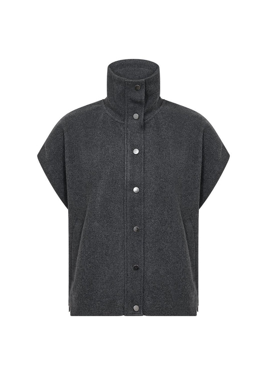 A woman stands outdoors among trees, wearing the Soya Concepts Dark Earth Vest over a cream ribbed long-sleeve dress, highlighting an eco-friendly style.