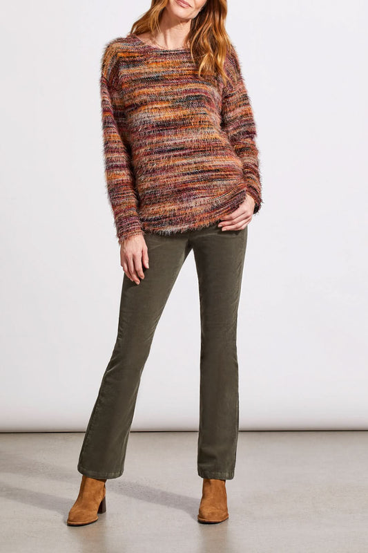 A person wearing a vibrant Tribal Soft Luxe Eyelash Long Sleeve Sweater in shades of orange, purple, and brown gently touches their hair.