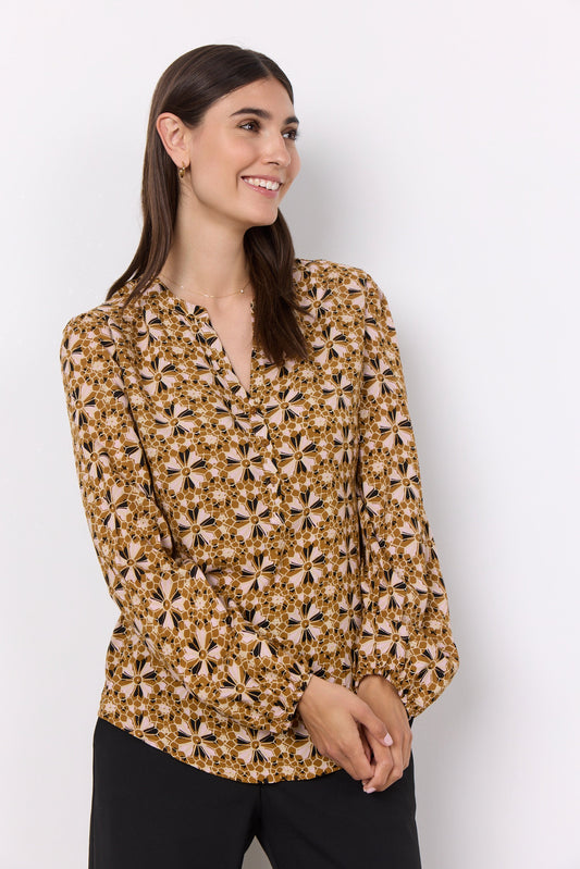A woman wearing a yellow TAMARA 1 blouse with a feminine blouse and LENZING™ ECOVERO™ viscose fabric by Soya Concepts.