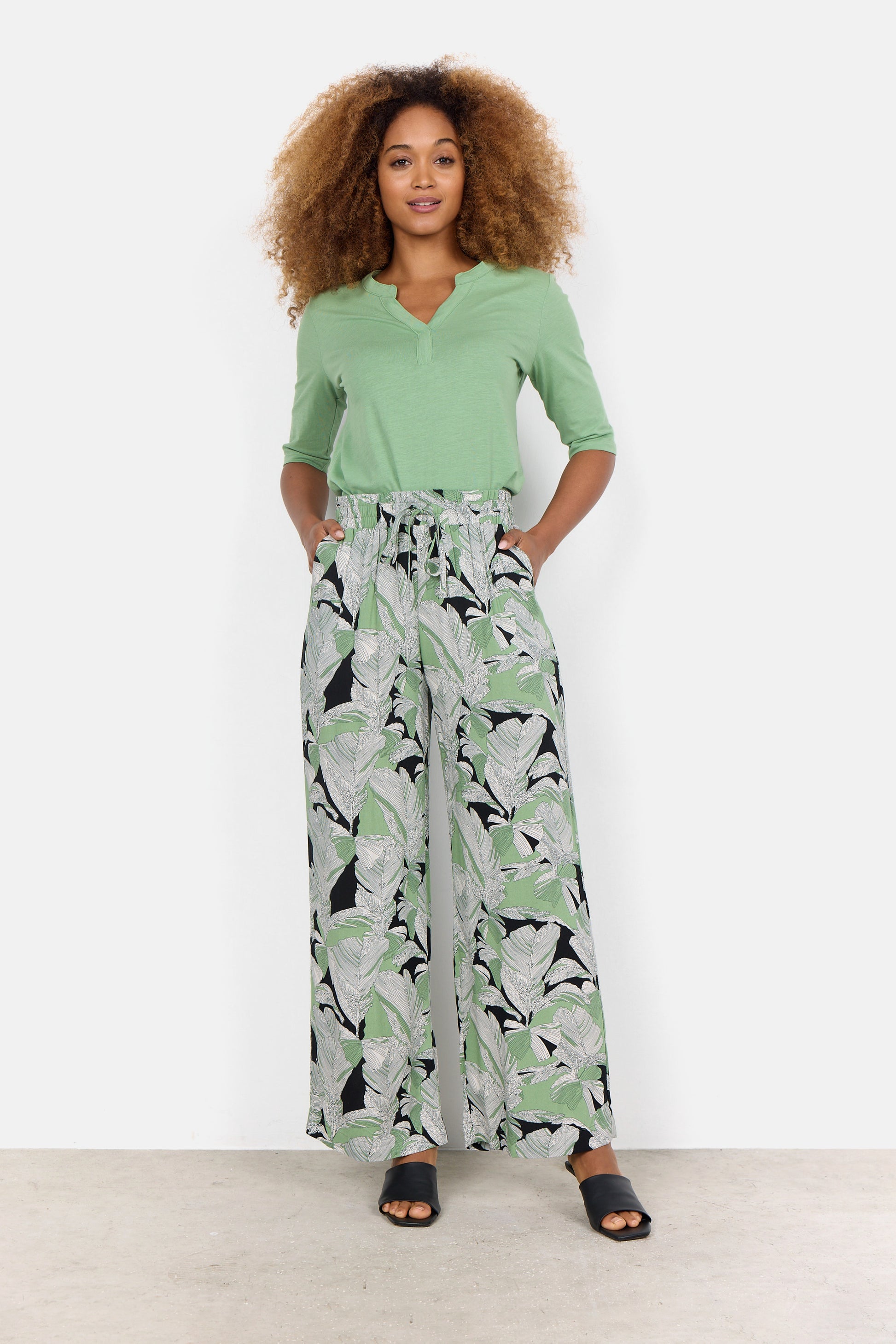 A woman in green Dauphin Wide leg Pant made from viscose sourced from certified wood by Soya Concepts.