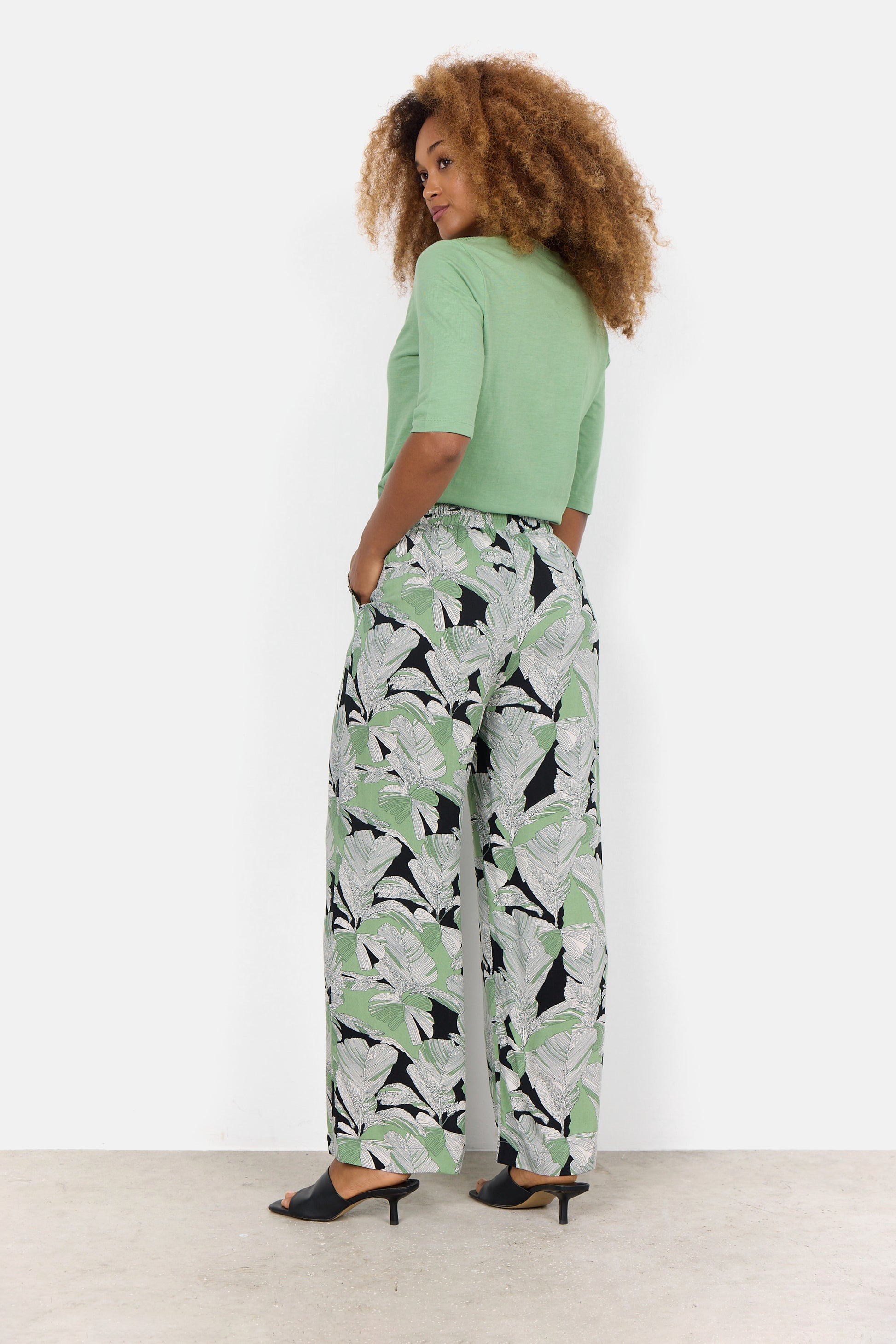 A woman in green Dauphin Wide leg Pant made from viscose sourced from certified wood by Soya Concepts.