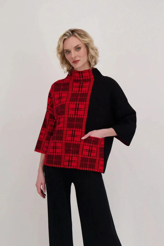 A person wearing the Gabby Isabella Two Tone Mock Neck Knit Top with black pants stands against a plain white background.