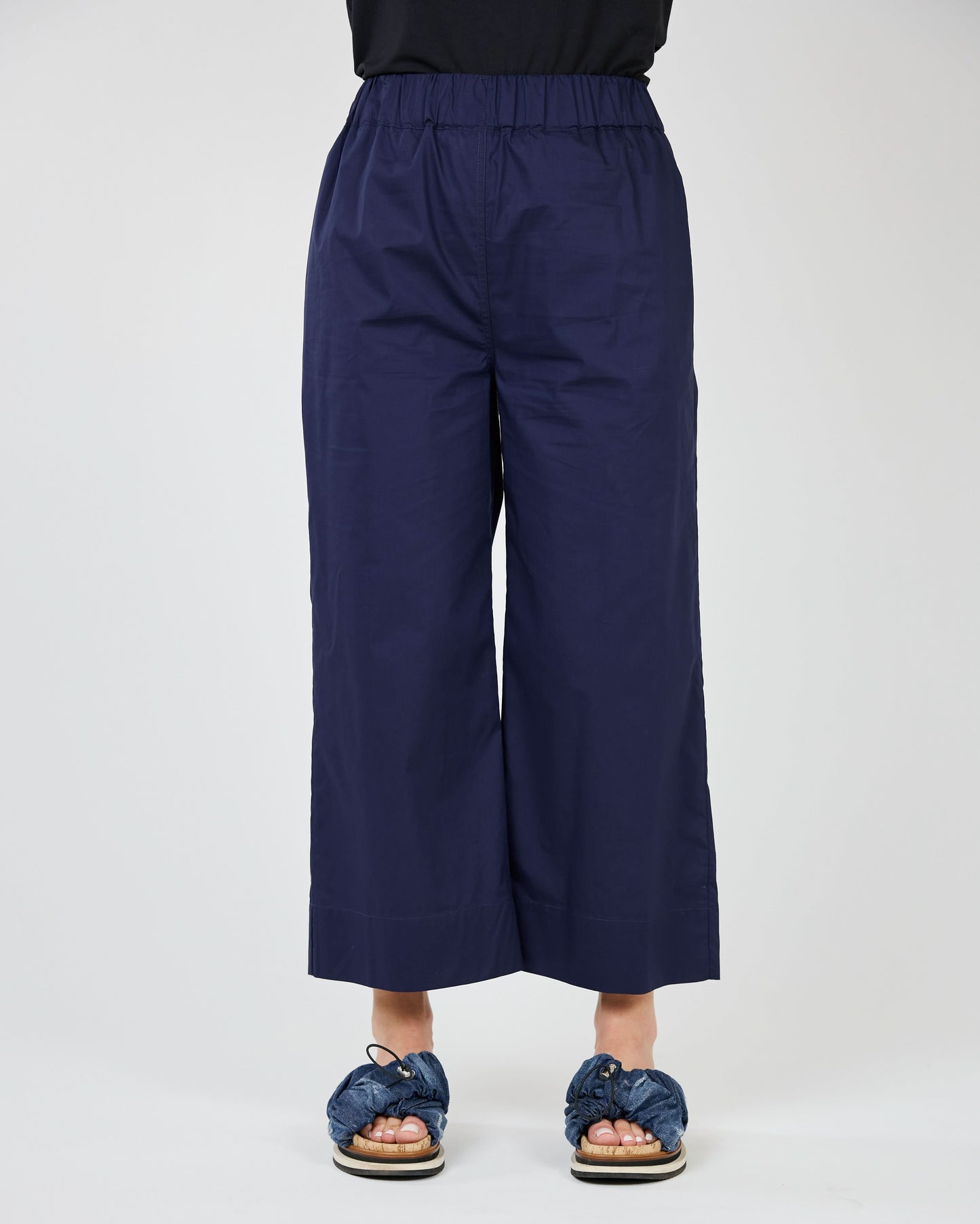 Person standing in Shannon Passero's Blake Wide Leg Crop Pant with a luxurious fabric and patterned slides against a neutral background.
