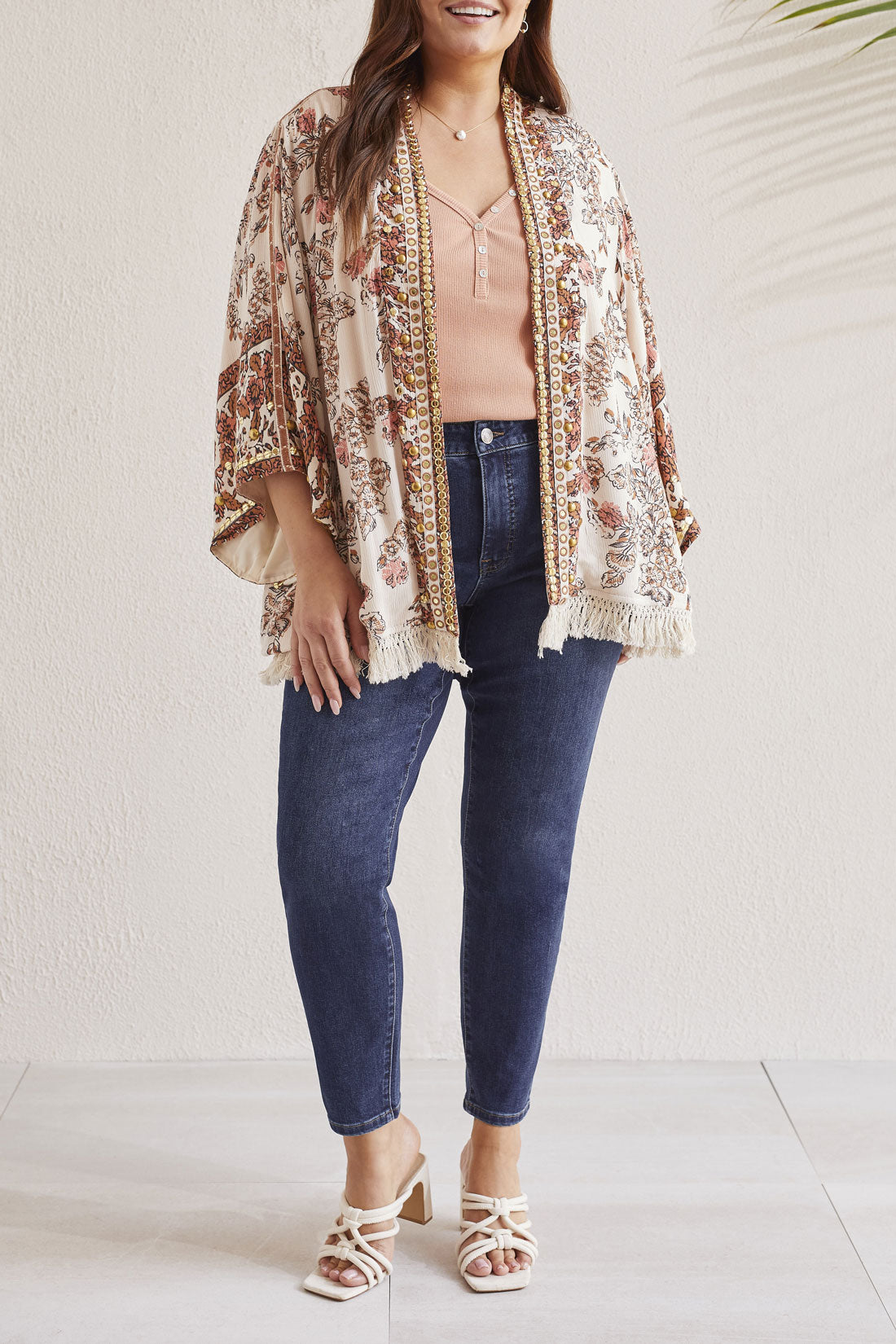 Person wearing a patterned, Tribal Embellished Lined Jacket, blue jeans, and white sandals.