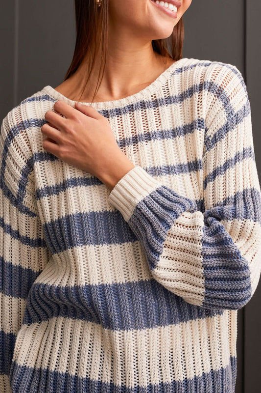 A woman in a beige and blue striped Wear 2 Ways Crew Neck/Cardi Sweater by Tribal with large buttons is smiling and crossing her arms.