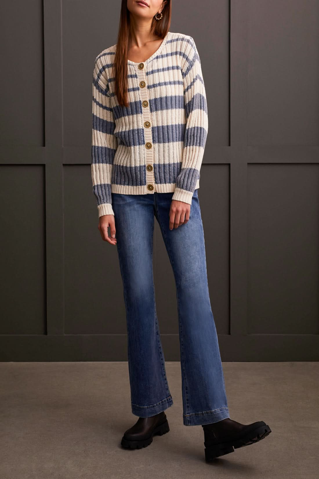 A woman in a beige and blue striped Wear 2 Ways Crew Neck/Cardi Sweater by Tribal with large buttons is smiling and crossing her arms.
