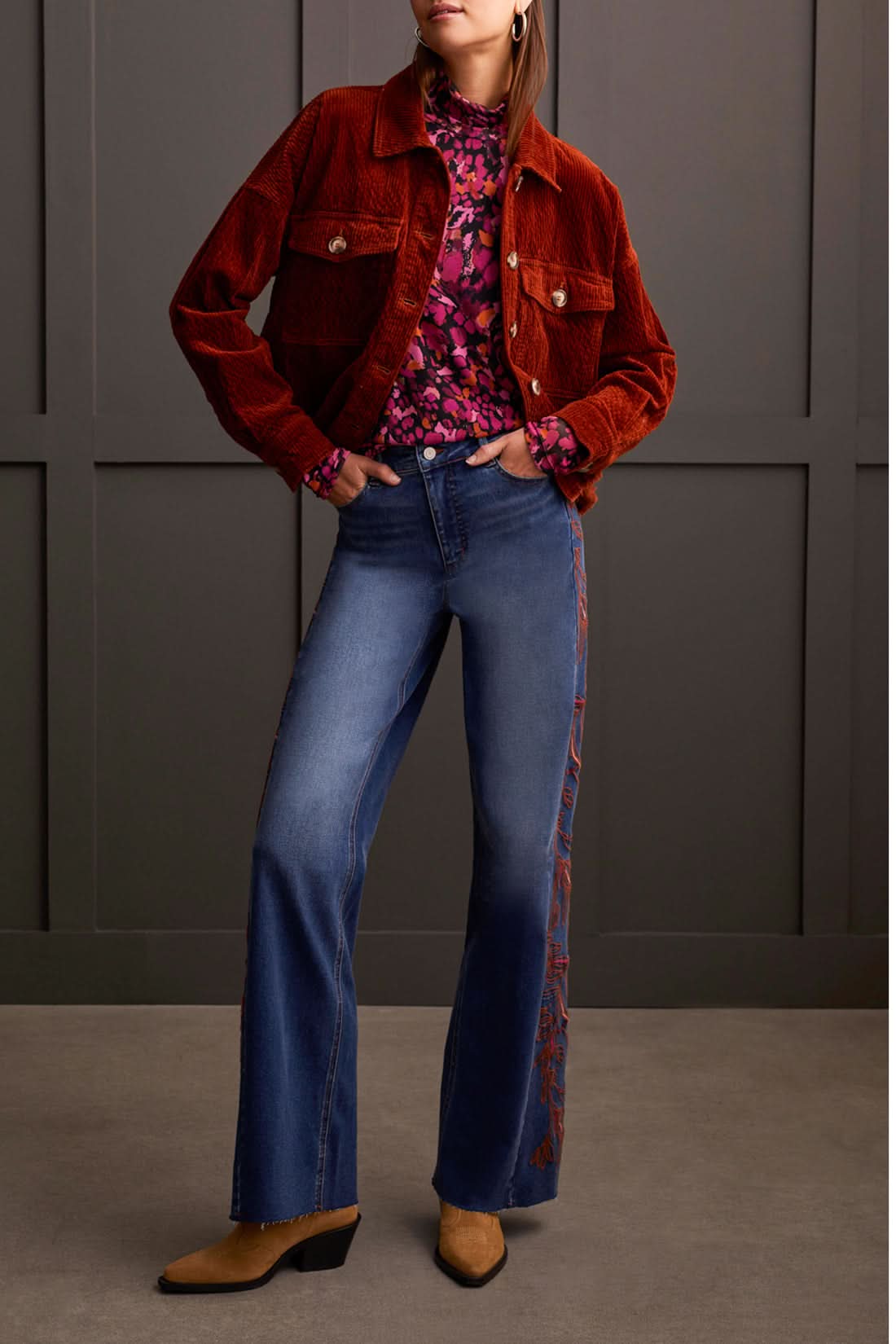 A person wearing a cozy Tribal Turtleneck Lined Top and high-waisted wide-leg jeans stands in front of a paneled wall. Brown shoes are visible at the bottom of the jeans, completing this perfect winter wardrobe look.