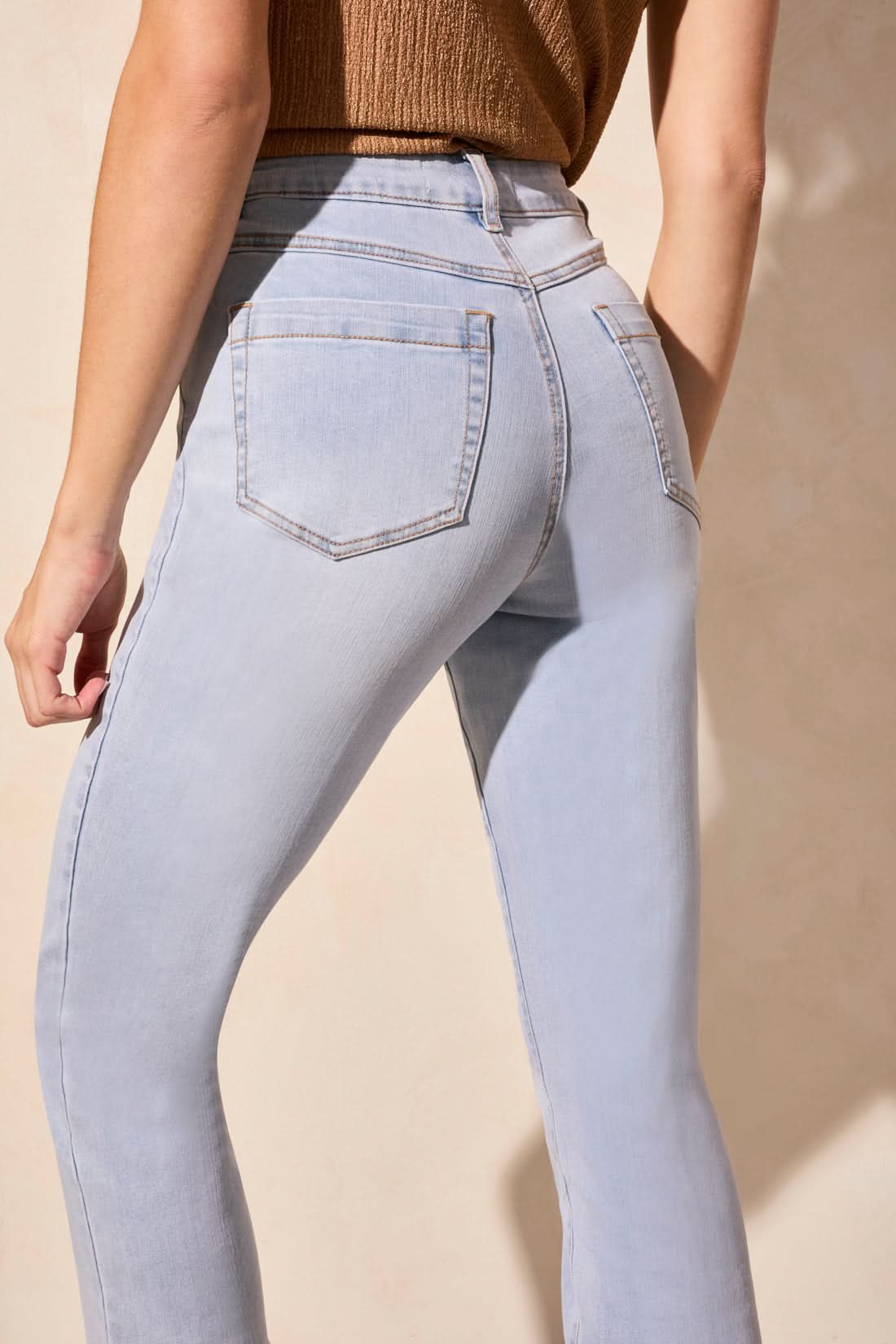 A person in a brown sleeveless top, AUDREY PULL ON STRAIGHT CROP JEANS by Tribal, and gray heels stands against a neutral background.
