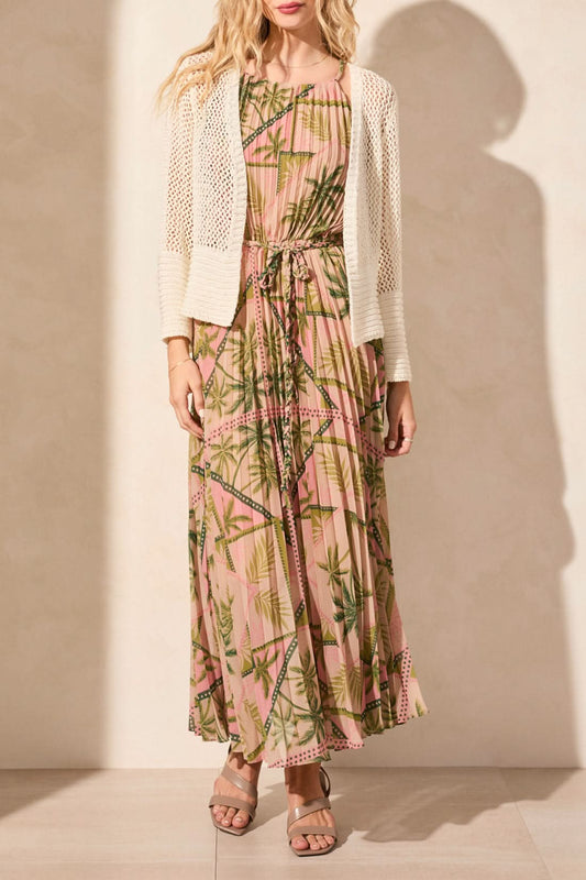 A person wears the "Tribal" crochet cardigan over a pink dress with a bamboo pattern. The BELL SLEEVE OPEN STITCH CARDIGAN features an open stitch design, offering luxurious comfort with textured sleeves and lightweight fabric.