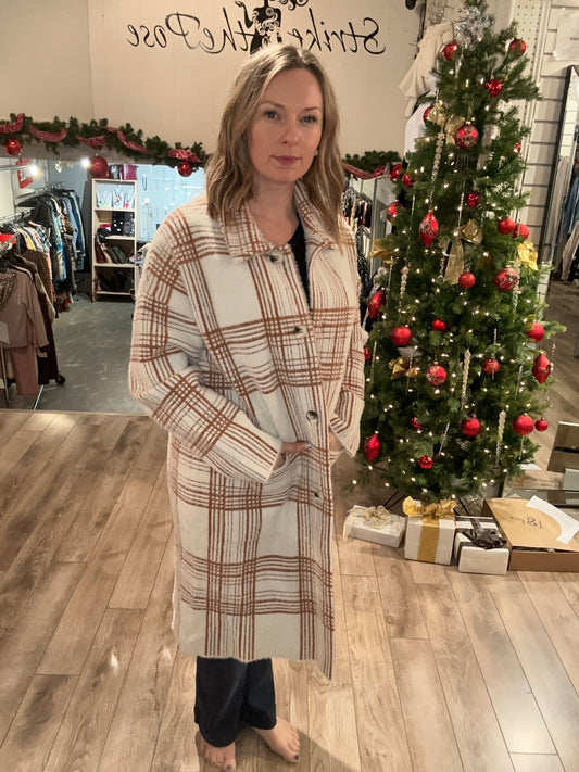 A woman in a plaid coat standing in front of a Christmas tree wearing the Carre Noir 6533 Knitted Cardigan.