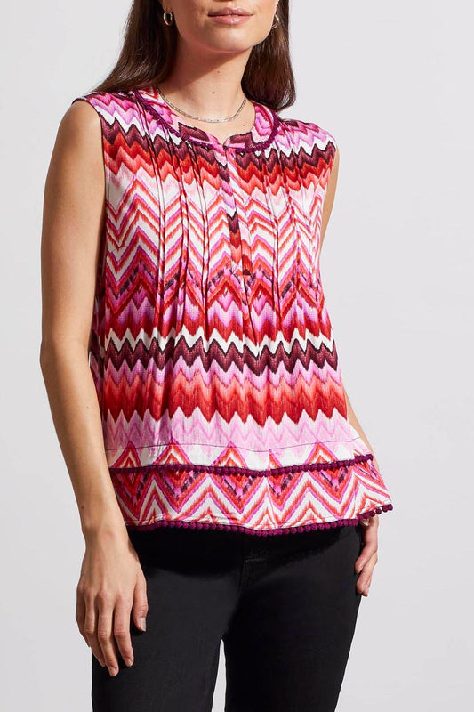 Woman wearing a trendy sleeveless Tribal top with a pink and white zigzag pattern.