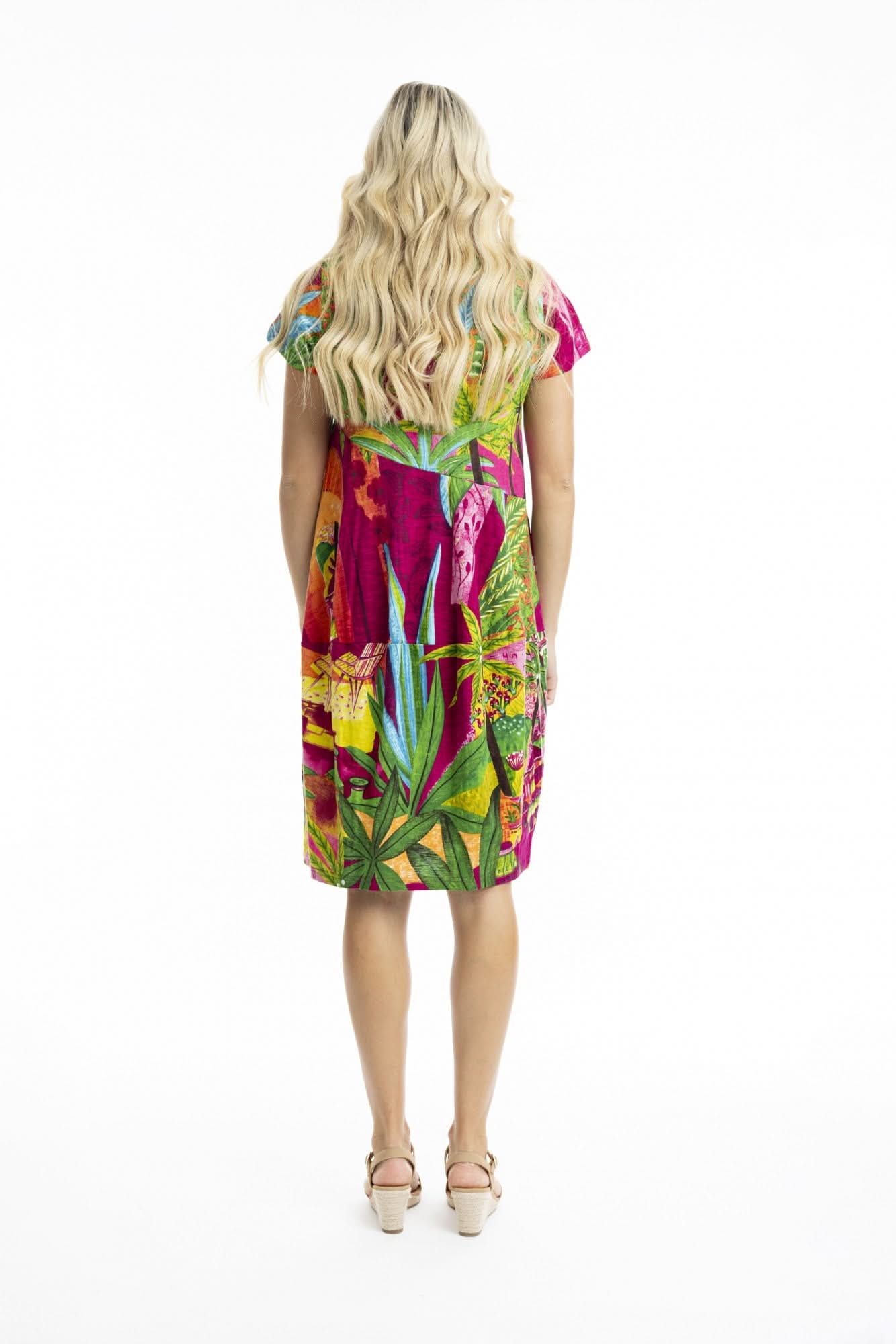 A woman poses against a white background in the Orientique Printed Cotton Short Sleeve Bubble Dress with a vibrant tropical print and beige sandals—ideal for adding playful style to your summer wardrobe.