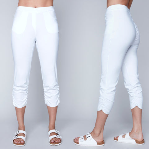 Front and side views of a person wearing Carre Noir Pull On White Capris and white sandals, exuding casual summer vibes against a gray background.