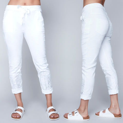 Front and back view of white Carre Noir crinkled crop pull on pants with a flattering fit on a model against a gray background.