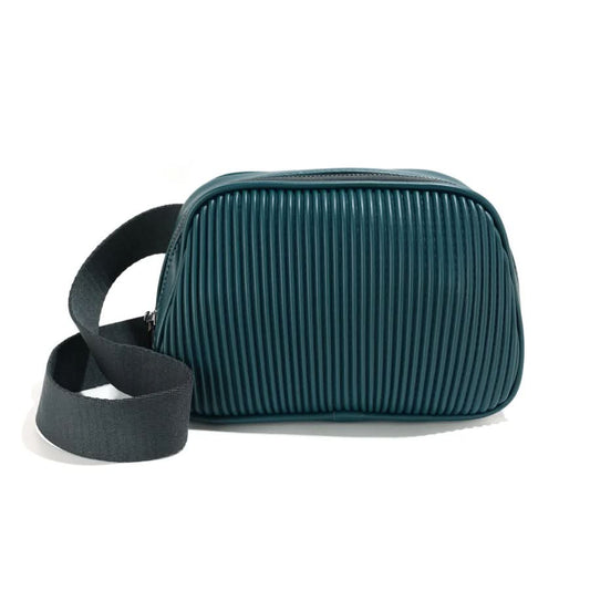 The Co-Lab Neoma sling bag features a small, rounded shape, teal vegan leather with a ribbed texture, and a wide black shoulder strap.