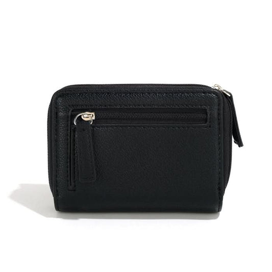 A person in a light gray shirt and beige pants holds The Lucie Small Wallet by Co-Lab, an eco-friendly, compact green wallet with both zipper and snap closures.