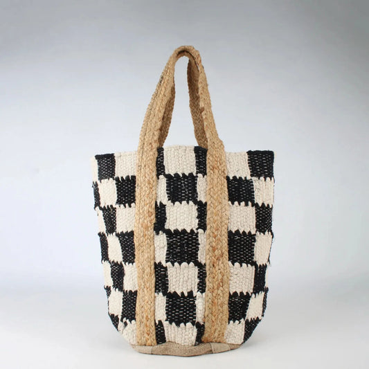 The Co-Lab Laguna Beach Tote Bag showcases a chic black-and-white checkerboard pattern and a sturdy woven jute handle, standing upright against a plain background.