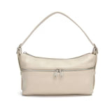 A woman in a sleeveless brown top and matching pants stands against a plain background, holding the Co-Lab THE 'MILA' SHOULDER BAG / CROSSBODY.