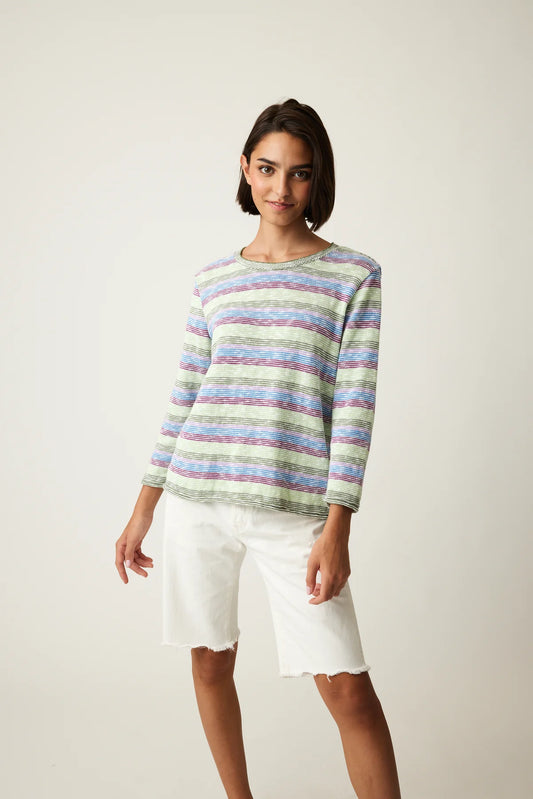 Woman posing in a Cotton Country striped sweater and white shorts against a neutral background.