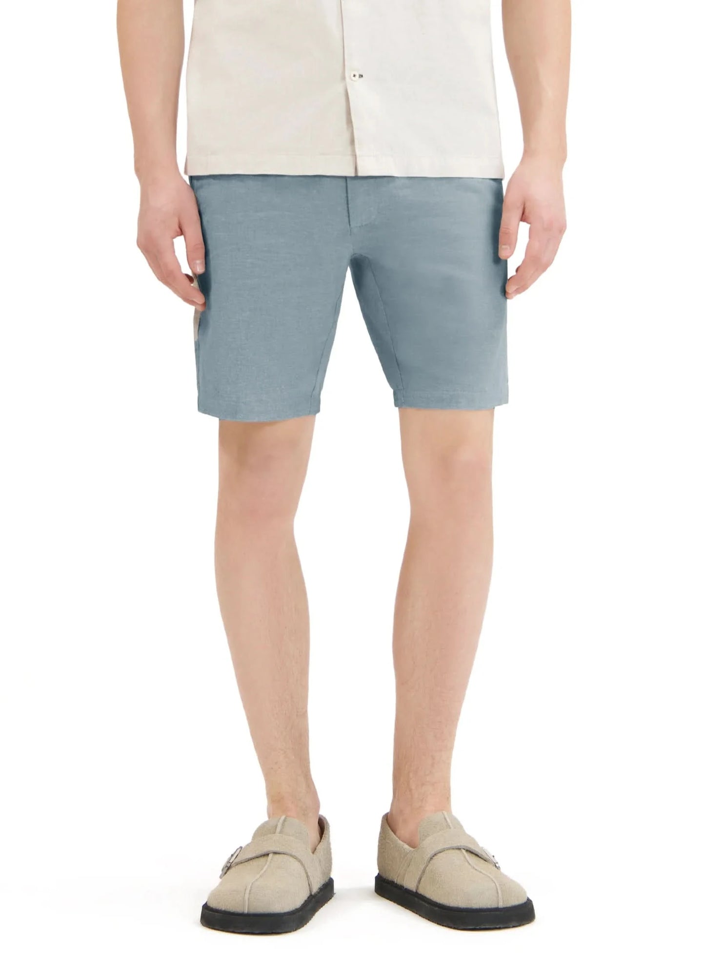Close-up of a person wearing Point Zero Mens Chino Linen Flat Front Shorts in blue and a white textured shirt, with their right hand by their side—showcasing an effortless summer look in breathable fabric.