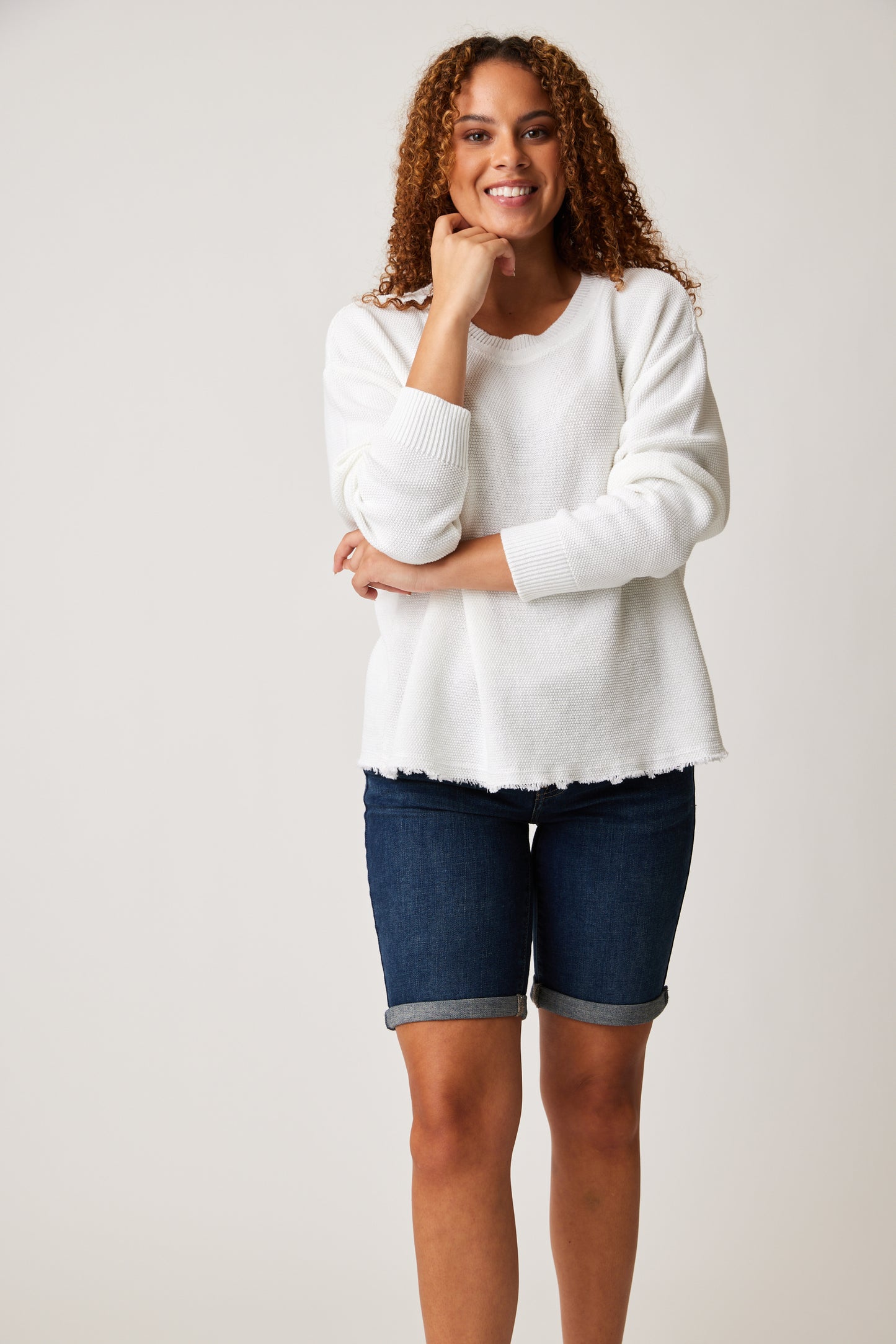 A woman looking stylish in a cozy white Cotton Country Sparrow Sweatshirt and skirt.