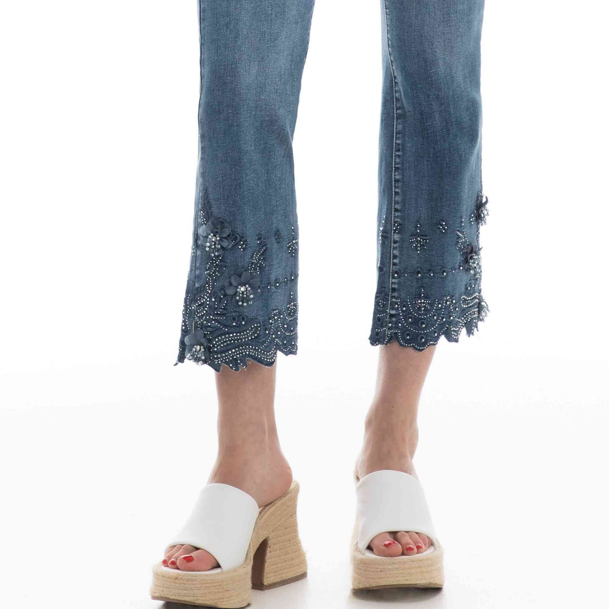 Woman wearing Orly's Flower Detailed Hem Jeans with floral detailing and white platform sandals.