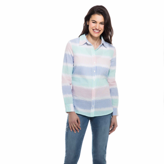 A fashionista smiling at the camera, wearing a Orly Blue Combo Striped Shirt and blue jeans, standing against a white background.