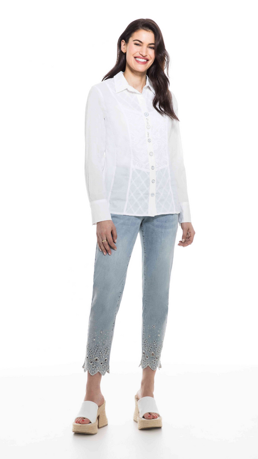 Woman smiling in an Orly button-up white collared blouse with lace details and jeans, wearing wedge sandals.