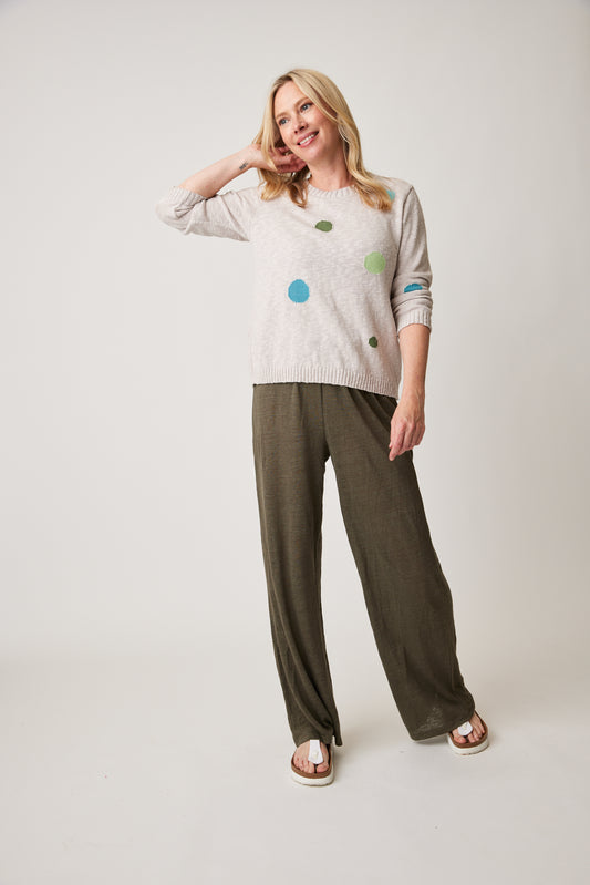 Woman posing in a casual outfit with a "Cotton Country Darling Dot Sweater" and trousers against a plain background.