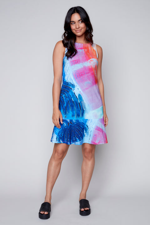 A woman stylishly dressed in a blue and pink Claire Desjardins Tulip Sleeveless Round Neck Dress.