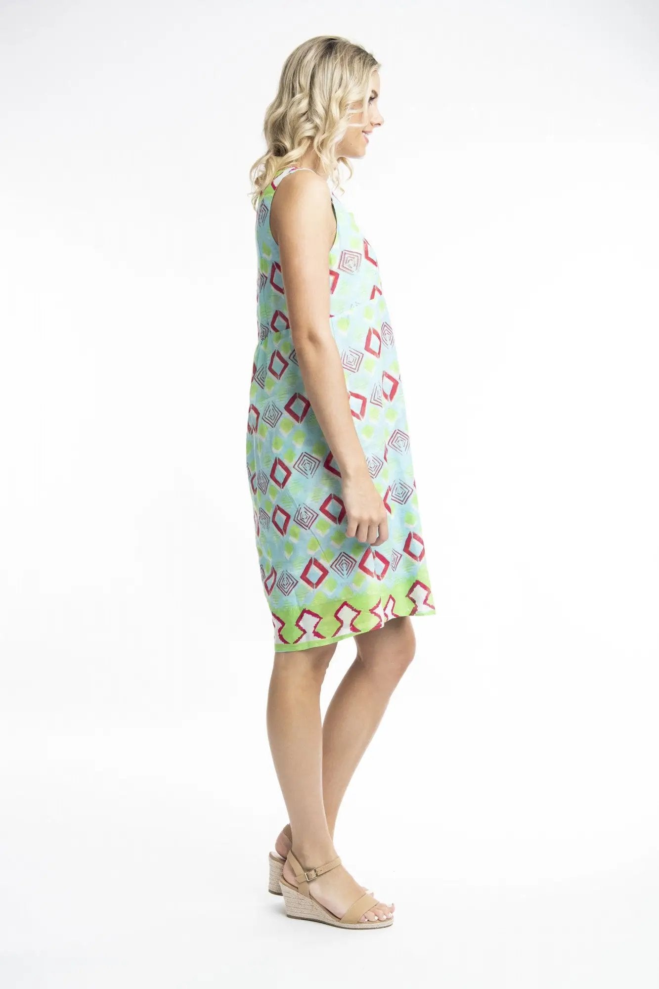 A woman smiling while posing in a Zio Turq Dress Reversible Sleeveless by Orientique on a white background.