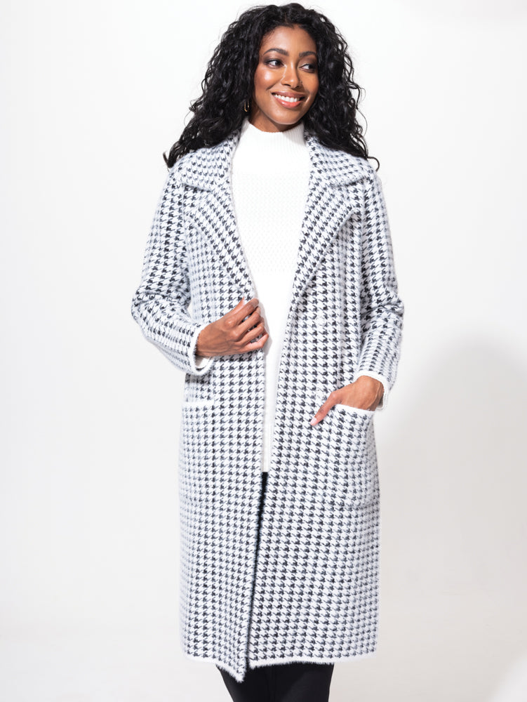 A woman wearing a cozy Alison Sheri black and white Houndstooth Cardigan.
