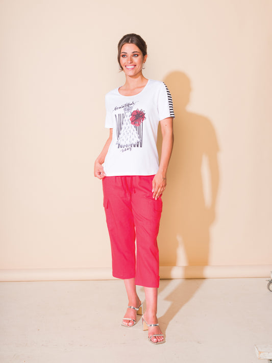 A woman exudes comfort and style in her Alison Sheri Motif T-Shirt paired with pink pants.