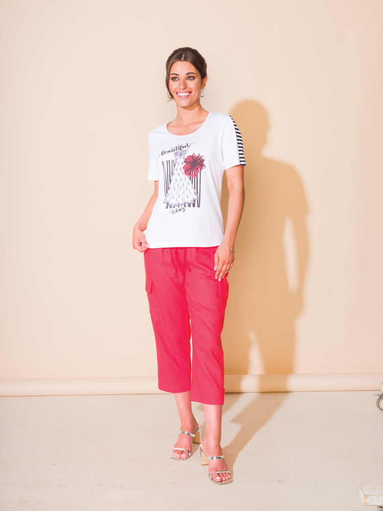 A woman exudes comfort and style in her Alison Sheri Motif T-Shirt paired with pink pants.