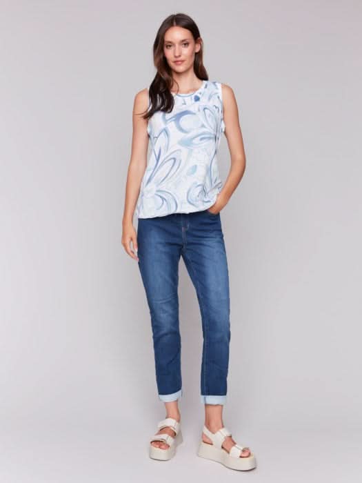 A woman models the Charlie B Sleeveless Organic Cotton Slub Knit Top with blue jeans, standing against a light background and smiling gently—an ideal choice for an easy, breezy summer look.