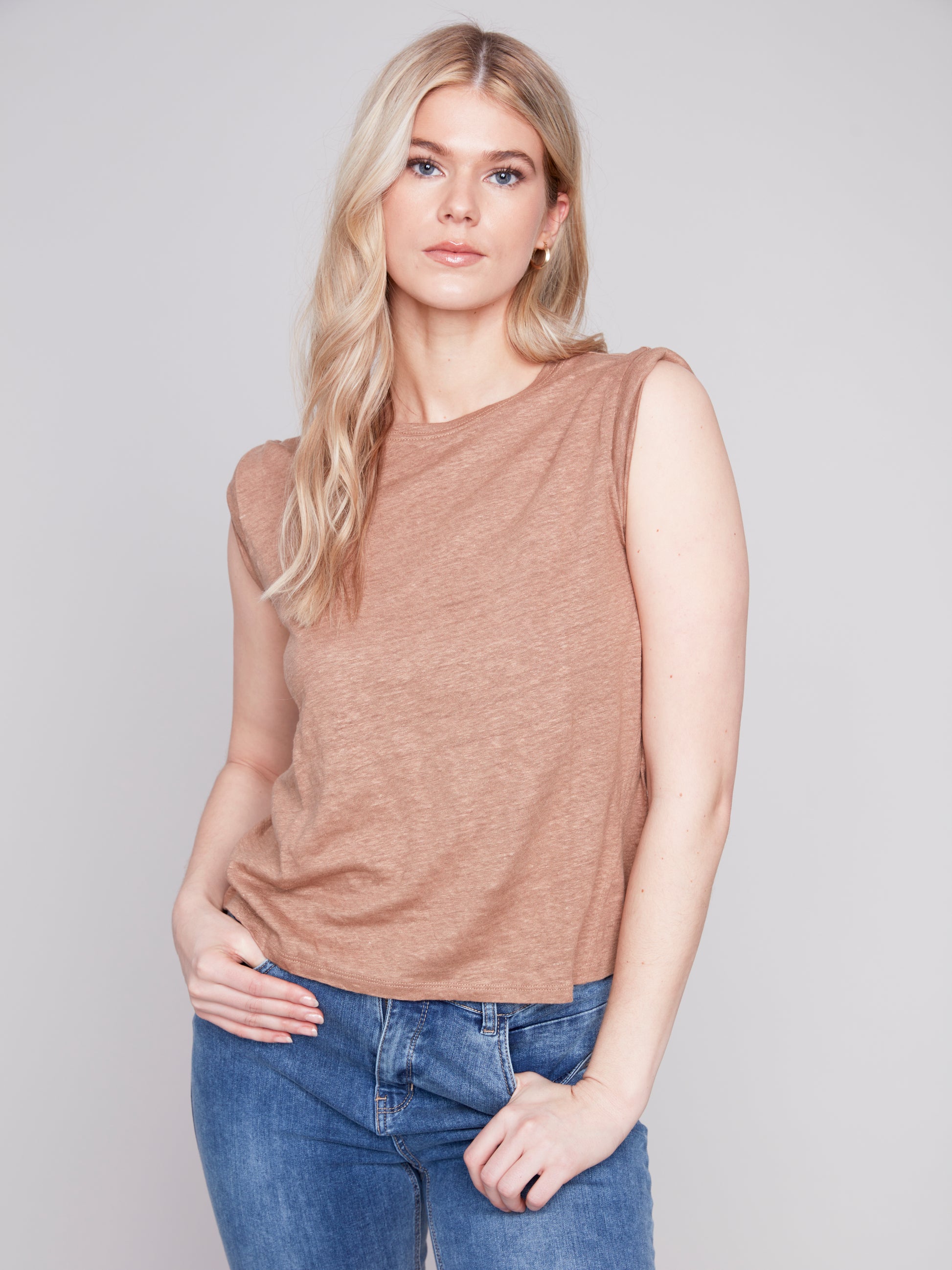 The model is wearing a Caramel Sleeveless Linen Tank by Charlie B and jeans.