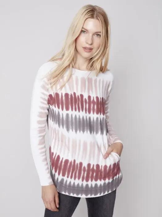 A comfortable woman wearing a raspberry-colored Charlie B Criss Cross Detailed Sweater.