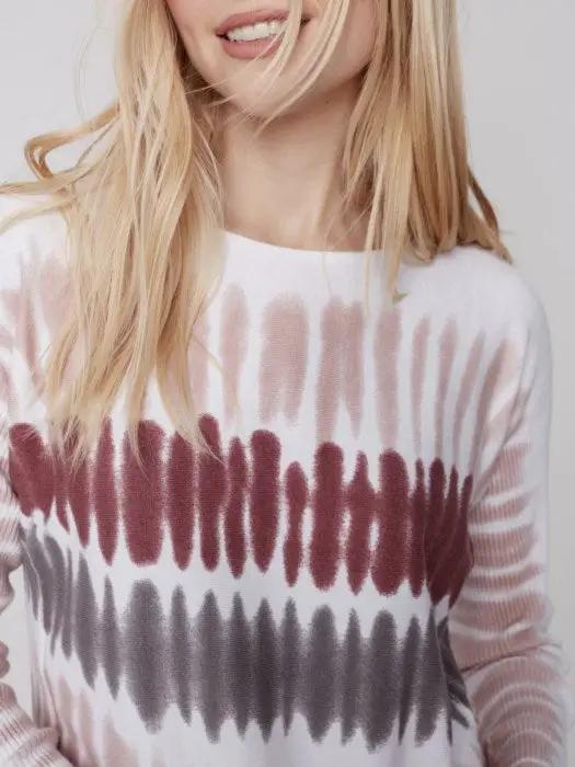 A comfortable woman wearing a raspberry-colored Charlie B Criss Cross Detailed Sweater.